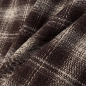 Close-up macro of brown and beige plaid flannel fabric with soft brushed texture