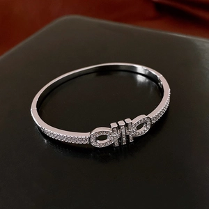 Détail macro du bracelet jonc argenté avec design double anneau et zircons étincelants