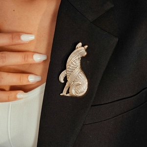 Detail showing vintage golden metal cat brooch with texture on a black blazer lapel