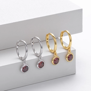 Detailed view of silver and gold S925 sterling silver earrings with round red gemstones