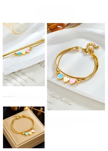 Detail of gold double-layer chain bracelet featuring colorful heart-shaped charms
