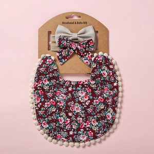 Coffret bavoir bébé fleuri et bandeau avec bordure pompon et petits nœuds