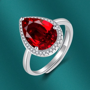 Detailed close-up of a pear-shaped red gemstone ring with sparkling zircon in silver finish