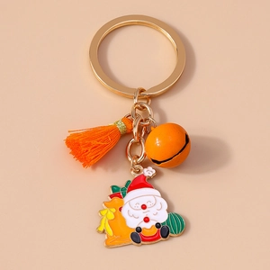 Detailed shot of Christmas keychain with Santa on a sleigh, orange tassel and golden bell