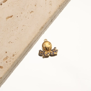 Macro detail of 18K gold-plated octopus pendant with blue crystals on starfish charm