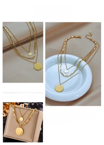 Close-up of layered gold titanium steel necklace with geometric round pendants