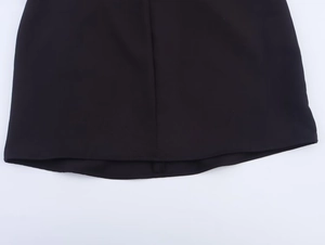 Detail van de zoom en fijne effen weefseltextuur van een zwarte mini-jurk