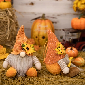 Two Thanksgiving gnome plush decorations with orange knit hats and sunflowers for harvest