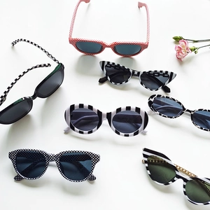 Flat lay of cat eye sunglasses in striped and checkered patterns on a white background