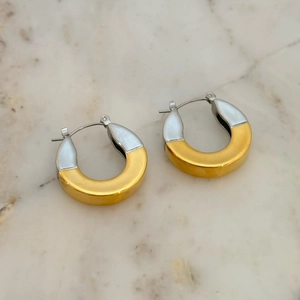 Two-tone 18k gold plated stainless steel wide C-hoop earrings on white marble background