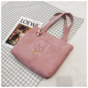 Pink corduroy tote bag detail with rabbit embroidery and cute cartoon pendant accessory