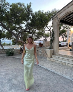 Detail of light green sequined maxi dress with thin straps and a backless slim fit