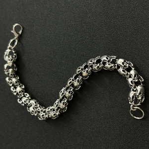Detailed macro view of silver hip-hop bracelet featuring skull-shaped metal links
