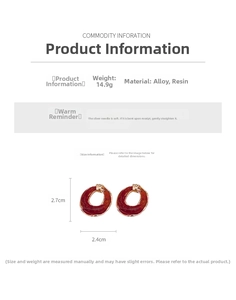 Detailed view of red-brown resin earrings with golden frames and silver needles