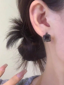 Close-up of elegant black square rhinestone earrings worn on an Asian model