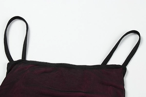 Detailaufnahme des Netz-Ausschnitts am weinroten Kleid mit schwarzen Trägern