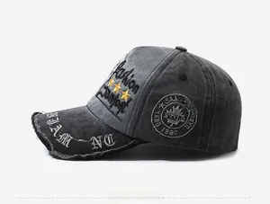 Detail of distressed dark grey baseball cap featuring vintage embroidery and star patches