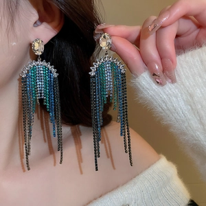 Macro shot of long tassel earrings with multicolored rhinestones and silver finish