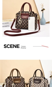 Detail of luxury monogram handbag with pearl heart pendant and elegant top handles