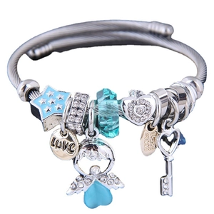 Pulsera plateada con dijes de estrella azul, corazón y ángel sobre fondo blanco