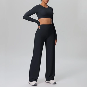Detail of high-waisted wide-leg yoga pants and fitted crop top in matte black fabric