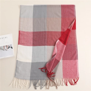 Macro detail of plaid cashmere-like scarf texture with dense fringes and warm colors