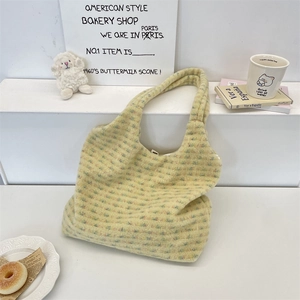 Close-up of fluffy plaid tote bag made of thick faux lamb wool with wide handles