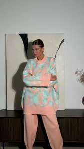 Close-up of pink and blue jacquard knit sweater set on a model in minimalist room