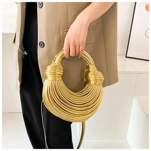 Detail of creative gold woven crossbody bag featuring a unique multi-layered tubular design