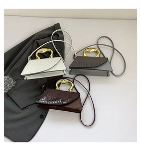 Three elegant top-handle bags in white grey and brown with unique gold irregular handles