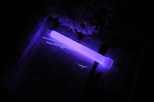 Close-up of a 6-inch purple glowing chem light stick with hook on a dark background