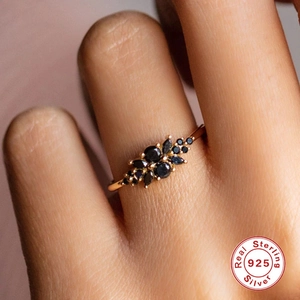 Detail of S925 sterling silver rose gold ring with marquise cut black stones