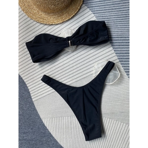 Black bikini set featuring 3D white mesh flowers and high-waisted bottoms on beach fabric