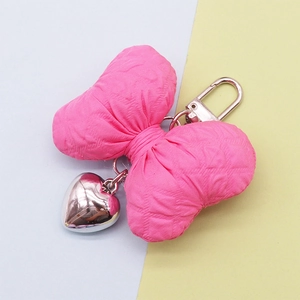 Pink quilted bow keychain with silver heart pendant and metal D-ring clasp detail