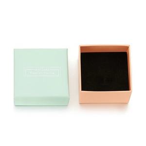 Detailed view of teal and peach jewelry gift box with black velvet sponge lining