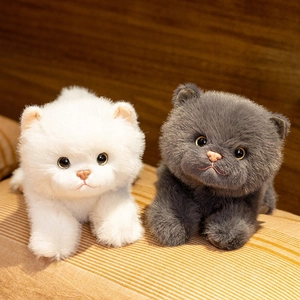 Peluches de gato British Shorthair blanco y gris tumbados sobre tela suave a rayas
