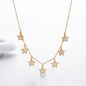 Detailed shot of gold star necklace with seven cubic zirconia inlaid pendants