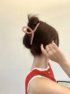 Detail of 13cm large claw clip with pink and brown spotted pattern on a woman's hair