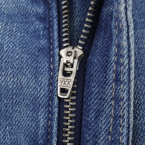 Nahaufnahme des YKK-Metallreißverschlusses und der Denim-Textur der blauen Jeans