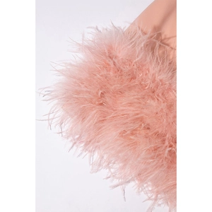 Détail de la bordure en plumes roses duveteuses et de la texture du tissu de la robe