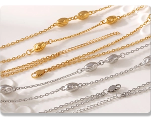 Close-up of gold and silver layered necklaces with lobster clasp and oval beads