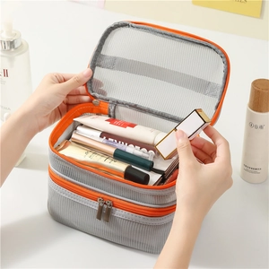 Minimalist grey mesh travel toiletry bag with orange zippers and double-layer storage