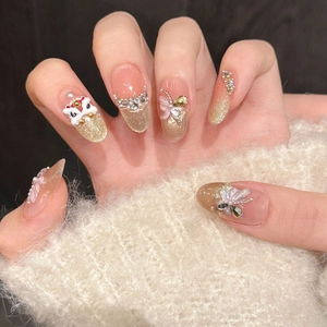 Detail of luxury press-on nails with golden lion dance charm and 3D butterfly accents