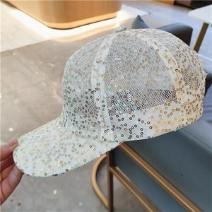 Detailed macro view of sparkling gold sequins on a white mesh baseball cap