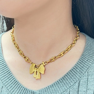 Massive 18K vergoldete Edelstahlkette mit feinem Schleifenanhänger am Model getragen