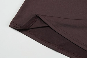 Macro shot of double-needle stitching and smooth hem detail on brown dress fabric