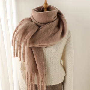 Gros plan sur l'écharpe en mohair marron rose avec texture douce et longues franges