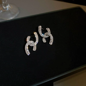Close-up of silver stud earrings featuring interlocking CC logo with crystal pavé stones