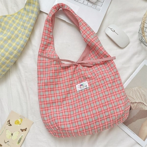 Detail of pink plaid fabric tote bag featuring cute bow decoration and happy day patch