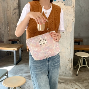 Lifestyle view of a vintage brocade pouch with marble pattern and PLEASANT TIME label